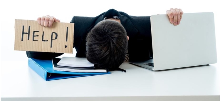 overwhelmed man at desk with help sign